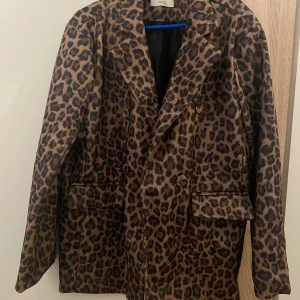 Leopardmönstrad kavaj  - Snygg kavaj med leopardmönster. Aldrig använt. Kavajen har dubbelknäppning. Perfekt plagg för dig som vill sticka ut.