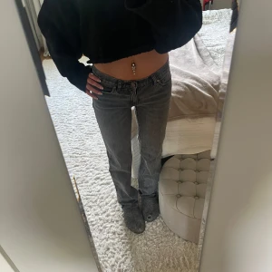 Grå Abrand Low Straight jeans - Säljer ett par grå jeans från Abrand Jeans, modellen 99 Low Straight. De har låg midja och raka ben, klassisk femficksdesign och en liten läderpatch på bakfickan. Jeansen är i ett coolt mörkgrått tvättat denimtyg som passar till allt.