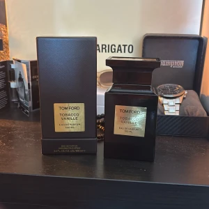 Tom Ford Tobacco Vanille 100ml EdP - Tom Ford Tobacco Vanille Eau de Parfum 100 ml. Lyxig parfym i mörkbrun, nästan svart, fyrkantig glasflaska med guldfärgad etikett och lock. Doften är känd för sina varma, kryddiga och söta toner av tobak och vanilj. Kommer med originalförpackning. Skulle säga att det är 95ml kvar då jag knappt använt den. Kan ta emot byten och priset kan diskuteras vid snabb affär