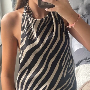 Zebramönstrad halterneck topp - Snygg zebramönstrad halterneck topp i svart och beige med öppen rygg och knyt i nacken!!🌸