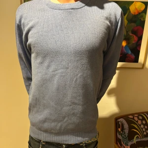 Ljusblå stickad tröja i bomull - En stilren ljusblå stickad tröja med rund halsringning och långa ärmar. Tröjan är enkel och passar perfekt till jeans eller chinos. Tillverkad i mjuk bomull för en skön känsla. Tröjan är från Zara i storleken M