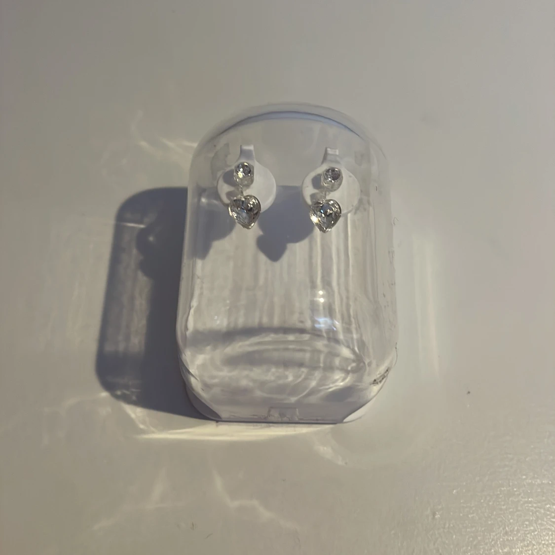 Silverfärgade örhängen med glittriga hjärtan