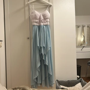 Vit och ljusblå klänning från Bodyflirt - Fin klänning från bodyflirt säljes! Nypris runt 700-800kr, endast använd på en skolavslutning! Axelbanden är uppsydda men går att sprätta upp🤗 Med uppsydda axelband gick klänningen nästan ner till marken (jag är 160cm)