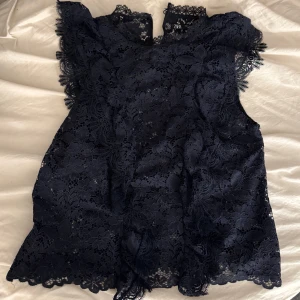 Mörkblå spetsblus - Elegant mörkblå spetsblus från Zar. Blusen är ärmlös och har en fin struktur som ger en lyxig känsla. Perfekt för att lyfta vilken outfit som helst. 🥹🥹