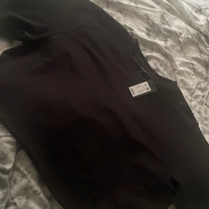 Svart Boxy Tee från 157 - Säljer en stilren svart Boxy Tee från 157 i storlek XS. T-shirten är tillverkad i bomull och har en avslappnad passform. Perfekt för en casual look.