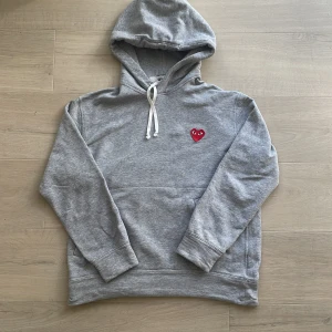 CDG hoodie - Säljer nu en riktigt schysst hoodie från märket ”Comme Des Garçons”. Tröjan är i toppenskick och inga defekter förekommer. Storlek Medium, men sitter något mindre i storleken. Hör av dig vid intresse! 💫