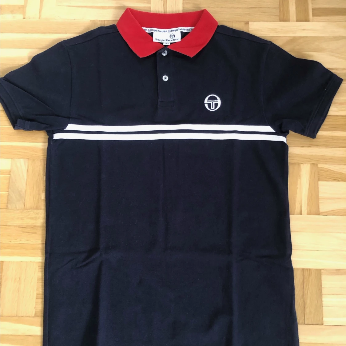 Svart pikétröja med röd krage från Sergio Tacchini