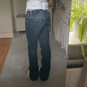 Blå jeansbyxor från Guess - Snygga blå jeansbyxor från Guess med låg midja och bootcut. Kommer tyvärr inte till användning längre. Inga defekter. Passar mig som är 170. Bilderna är lånade från tjejen jag köpte dem av. Fråga om du vill ha flera bilder. Pris kan diskuteras. 