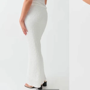 Vit långkjol - Snygg vit långkjol med en tight passform. Kjolen har en enkel och stilren design som passar perfekt för olika tillfällen. Materialet ger en elegant look.