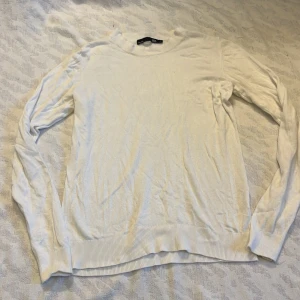 Vit tunn tröja - Säljer en stilren vit tunn tröja från 157. Den har en klassisk design med långa ärmar och ribbade muddar vid ärmslut och nederkant. Perfekt för en enkel och snygg look. Den ska såklart strykas