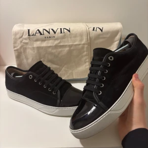 Lanvin sneakers - Svarta Lanvin Patent Cap Toe Sneakers i jättefint skick, sparsamt använda ett par gånger. Storlek UK 9 vilket passar 43-44, box och dustbags medföljer. Pris kan diskuteras vid snabb affär! Vid frågor eller funderingar, behov av fler bilder eller liknande är det bara att skriva!😊