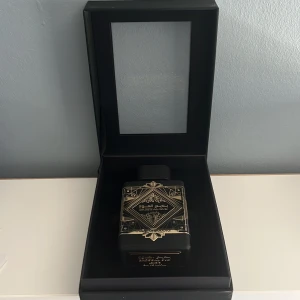 Badee Al Oud Oud for Glory Parfym - Elegant parfym i en lyxig svart och guld flaska. Förpackningen har en sofistikerad design med orientaliska mönster. Perfekt för den som söker en doft med djup och karaktär.