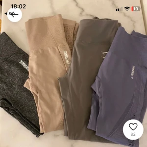 Träningsleggings från Gymshark - Säljer ett set av träningsleggings från Gymshark i olika färger: grå, beige, lila och mörkgrå. De är högmidjade och har en tight passform, perfekta för träning. Materialet är stretchigt och bekvämt. Styckpris 200/ par