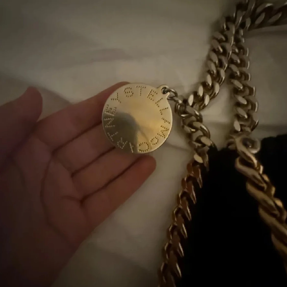 Svart axelväska med kedjedetaljer kan mötas upp - 1