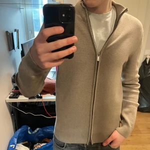 Cardigan  - Säljer en beige cardigan/fullzip i storlek S. Den är använd ungefär 10 gånger. Hör av er vid fler frågor!