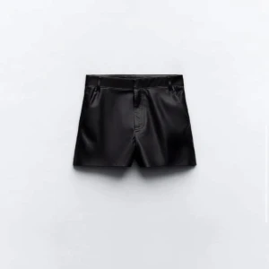 Svarta skinnshorts - Snygga svarta skinnshorts med en stilren design från zara. De har en klassisk passform med dragkedja och knapp framtill. Perfekta för en trendig look. Kommer inte till användning!💕💕