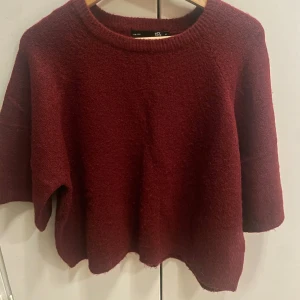 Vinröd stickad tröja - Mysig vinröd stickad tröja med rund hals och trekvartsärmar. Perfekt för kyliga dagar och enkel att matcha med olika outfits. Ett måste i garderoben för höst och vinter! Aldrig använd och jätte fint skick!! 