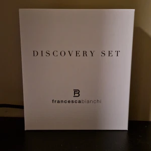 Discovery Set från Francesca Bianchi - Upptäck Francesca Bianchis värld med detta Discovery Set innehållande 14 olika doftprover à 1,5 ml. Perfekt för att utforska en rad unika och känslomässiga dofter. Setet kommer i en stilren vit förpackning med texten 'liquid emotions'.