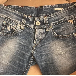 Blå jeans från Replay - Snygga blå jeans från Replay med en sliten look och låg midja. De har klassiska fem fickor och en knappgylf. Midjemåttet är 38 tvärs över och jag är 160 för referens🩷
