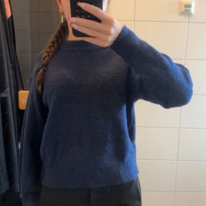 Mörkblå stickad tröja - Säljer en mysig mörkblå stickad tröja med långa ärmar. Perfekt för kyligare dagar och ger en stilren look. Passar bra till både jeans och kjol. Aldrig använd 