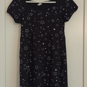 Babydoll klänning med puffärmar och stjärnor - Super söt svart babydoll klänning med silvriga stjärnor!✨ Inga defekter och har fina puffärmar. Passar utmärkt på XS! Från H&M.