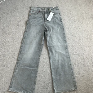 Grå wide jeans från Perfect Jeans - Gråa jeans i modellen comfy wide från Perfect Jeans. De har hög midja, raka och vida ben samt klassisk femficksdesign. Jeansen är tillverkade i mjukt denimtyg och har snyggt tvättad finish. Perfekta för en avslappnad och trendig look.