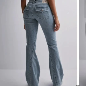 Ljusblå bootcut jeans med fickdetaljer - Snygga ljusblå jeans med bootcut passform och klassiska fickor med lock och knapp bak. Från True Religion i storlek 26.( priset kan diskuteras eller byta💕)