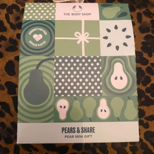 The Body Shop Pears & Share Mini Gift - Snyggt presentkit från The Body Shop med Pears & Share-serien. Innehåller en vegansk body butter (50 ml) och duschgel (60 ml) med päron, slånbär och pion, samt en vit badsvamp. Fräscha gröna och lila detaljer på förpackningarna, perfekt för dig som älskar fruktiga dofter och mjuk hud.