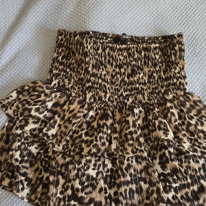 Volangkjol - Snygg kort kjol från Sisters Point med leopardmönster i bruna och beige toner. Kjolen har smockad midja och dubbla volanger! Kjolen är stretchig och passar mellan s-L! Kjolen går att ha båda highwaist och low waist och går att vika ner kanten för ännu mer low waist! Skriv om du har några frågor eller om du vill köpa/ är intresserad av att köpa!! Pris kan diskuteras!🫶
