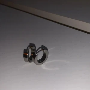 Silvriga hoops örhängen - Säljer ett par stilrena (med små symboler längst med framsidan baksidan är blank) chunky hoops i silverfärgad metall. De är små, runda och har en enkel, modern design som passar perfekt till en clean look. Lätta att klicka i och ur örat. Perfekta för dig som gillar minimalistiska smycken. Bara använda en gång.Har man frågor eller vill ha fler bilder så är det bara att skriva. OBS FINNS UTE PÅ FLER SIDOR (går att posta med vykort om man vill det)