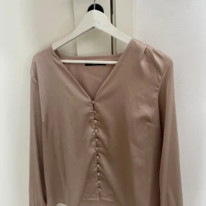 Beige omlottklänning med knappar - Supersnygg blus ifrån bik bok som knappt använts 
