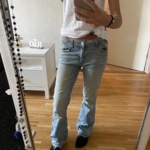 Ljusblå bootcut jeans  - Säljer ett par ljusblå jeans från Ginatricot. Jeansen har låg midja och är bootcut. Finns ett litet hål i bakfickan, därav priset. Storlek 152 (barnstorlek), passar XS. 