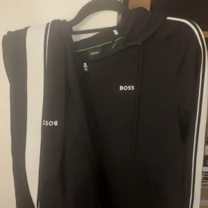 Svart o vit Hugo boss sett - Svart o vit Hugo boss sett säljs. Mycket bra kvalité. Köpt för 1500kr. Storlek S men skulle även passa M. Går också att bara köpa en av plaggen, ex överdelen enskilt eller byxorna. Pris kan diskuteras!