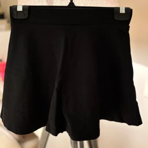 Barnkjol svart - Svart kjol med elastisk midja. De är enkla och stilrena utan mönster eller detaljer, perfekta för en chill och avslappnad look. Tillverkade i mjuk bomull som känns skön mot huden. Storlek 134/140 🌸🩷