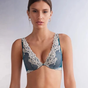 Blå spets bralette med blommig spets - Superfin blå bh med breda axelband och vacker blommig spets i offwhite. Djup v-ringning och meshdetaljer ger en romantisk vibe. 