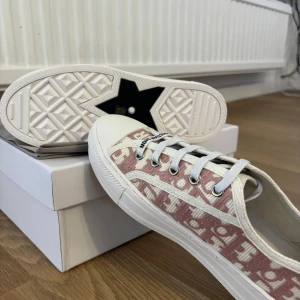 Dior sneakers i rosa och vitt - Hej! 🌸 Jag säljer nu alla tjejers drömskor – helt nya och i perfekt skick, utan några skador. Den vackra rosa färgen passar till allt, och du får självklart med både originalkartong och dust bag. 💕 Är du intresserad? Skriv gärna till mig! 
