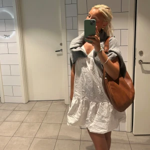 Vit kortklänning - Supersöt vit kortklänning med omlott-v-ringning och volang nedtill. Fåtall gånger använd