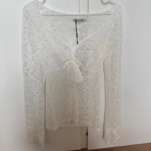Vit spetsblus med knyt från Design by Si - Supersöt vit blus i spets från Design by Si, med prislappen kvar!!! Xs/s