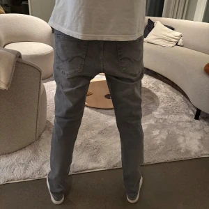 Grå jeans i straight fit - Säljer ett par slim fit/ Glenn modell jeans från Jack and Jones, jeansen är i mycket bra skick! W-30 L-32