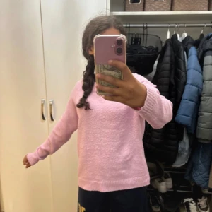 Ljusrosa stickad tröja Vero Moda - Supermysig ljusrosa stickad tröja från Vero Moda i storlek S. Tröjan har rund hals, ribbade muddar och lång ärm. Perfekt för att chilla hemma eller hänga med kompisar. Enkel och stilren design som är lätt att matcha med jeans eller mjukisbyxor.