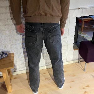 Mörkgrå Lee Oscar jeans W33 L32 - Säljer ett par mörkgrå Lee Oscar jeans i klassisk straight fit med normal passning. Jeansen har fem fickor, tydliga sömmar och Lee-logga på knapp och etikett. Materialet är slitstarkt denim i bomull och de har dragkedja i gylfen. Hör av er vid frågor!