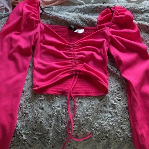 H&M  - Hot pink lång ärmad tröja croppad men man kan dra åt fram sidan och göra den större och mindre med snörerna 