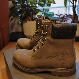 Timberland damkängor olive nubuck - Nyskick, endast provade ett par gånger, aldrig varit utomhus! De är i storlek 37,5 men är ganska små i storlek så skulle säga att de är lagom för någon med 36/36,5. (jag har 37 i storlek vanligtvis men dessa blev för tight, speciellt med en tjockare strumpa i).  De har en liten skavank från produktion (se bild 3) därav det lägre priset! 
