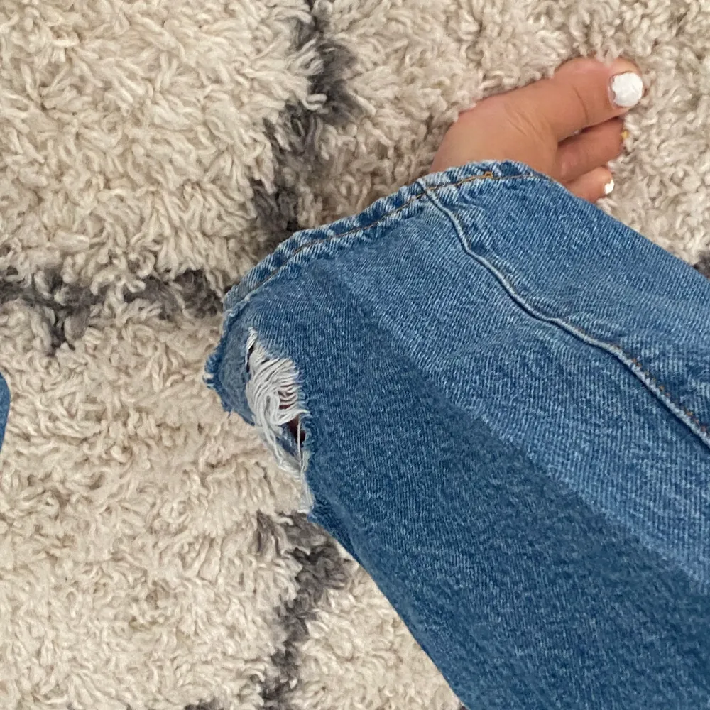 Mörkblå jeans med hål på knäna från Gina Tricot! Använda ett fåtal gånger, i bra skick förutom en slitning längst ner på höger ben. Frakt tillkommer, storleken är 34 men passar 36. Jeans & Byxor.