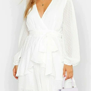 Klänning Boohoo - Helt oanvänd klänning. Vit färg, volanger, skater dress modell. Storlek 46. Jag har vanligtvis storlek L i klänningar. Passar dig som har L-XL!