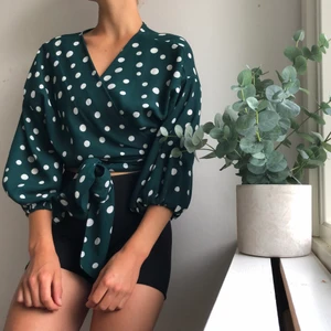 Prickig blus - En jättesöt grön/vit prickig blus som knyts om midjan, passar till lite högmidjade byxor m.m. Storlek M