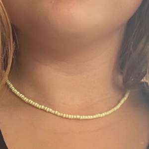 Pärl halsband med justerbart längd i bak och färg gul 
