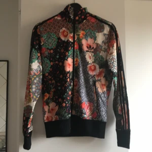 Adidas jacka  - Tre år gammal Adidasjacka köpt i London, Sorlek 38 Tre svarta ränder på armarna och adidasmärke på ryggen. Finns inte så många ex med just det här mönstret. Känns som ny då jag inte använt den så mycket Allt är intakt, dragkedja och muddar o sömmar. 