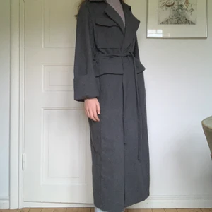 Lång kappa från gina tricot - En lång mörkgrå kappa från gina tricot! Den går ner till vaderna på mig som är 175 cm. Jag har använt den en halv vinter och den är i nyskick. ☺️                                     Köparen står för frakten! 99 kr