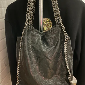 Tiamo väska - En svart tiamo väska, säljer billigt pga att den är defekt på baksidan, men inget som syns när man har den över axeln. Allt annat är helt och funkar